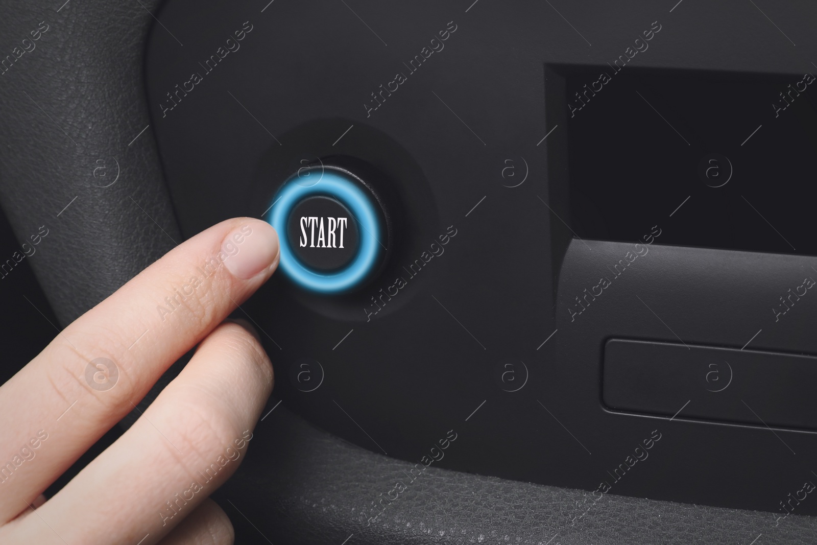Image of Woman pressing start button in car, closeup