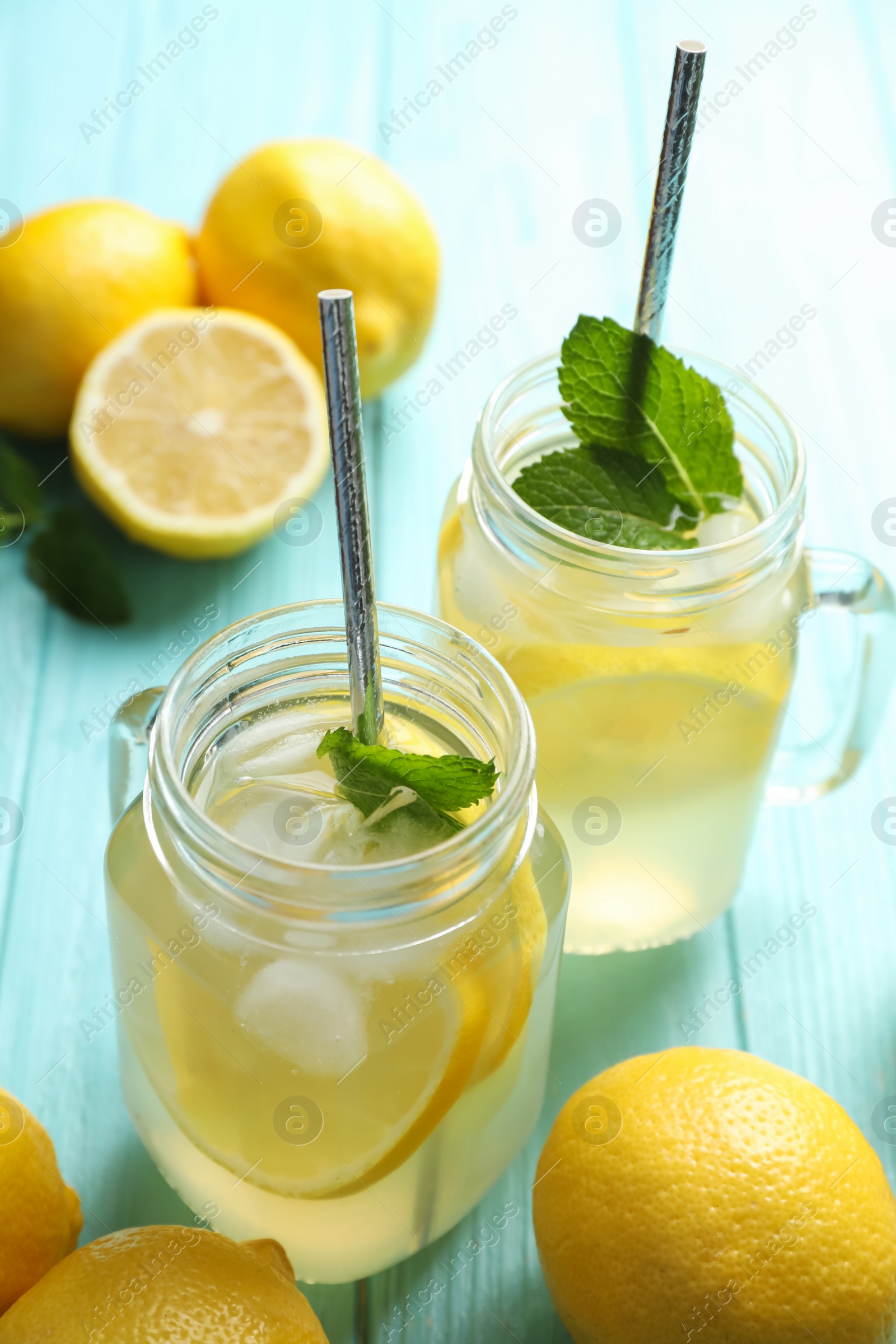 Photo of Natural lemonade with mint on light blue wooden table. Summer refreshing drink