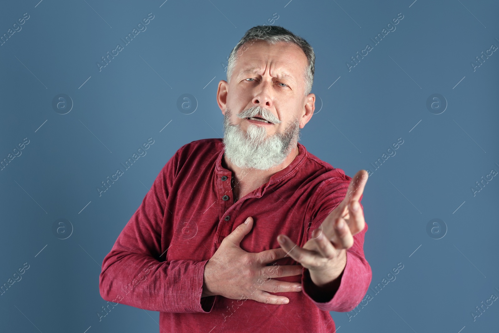 Photo of Mature man having heart attack on color background