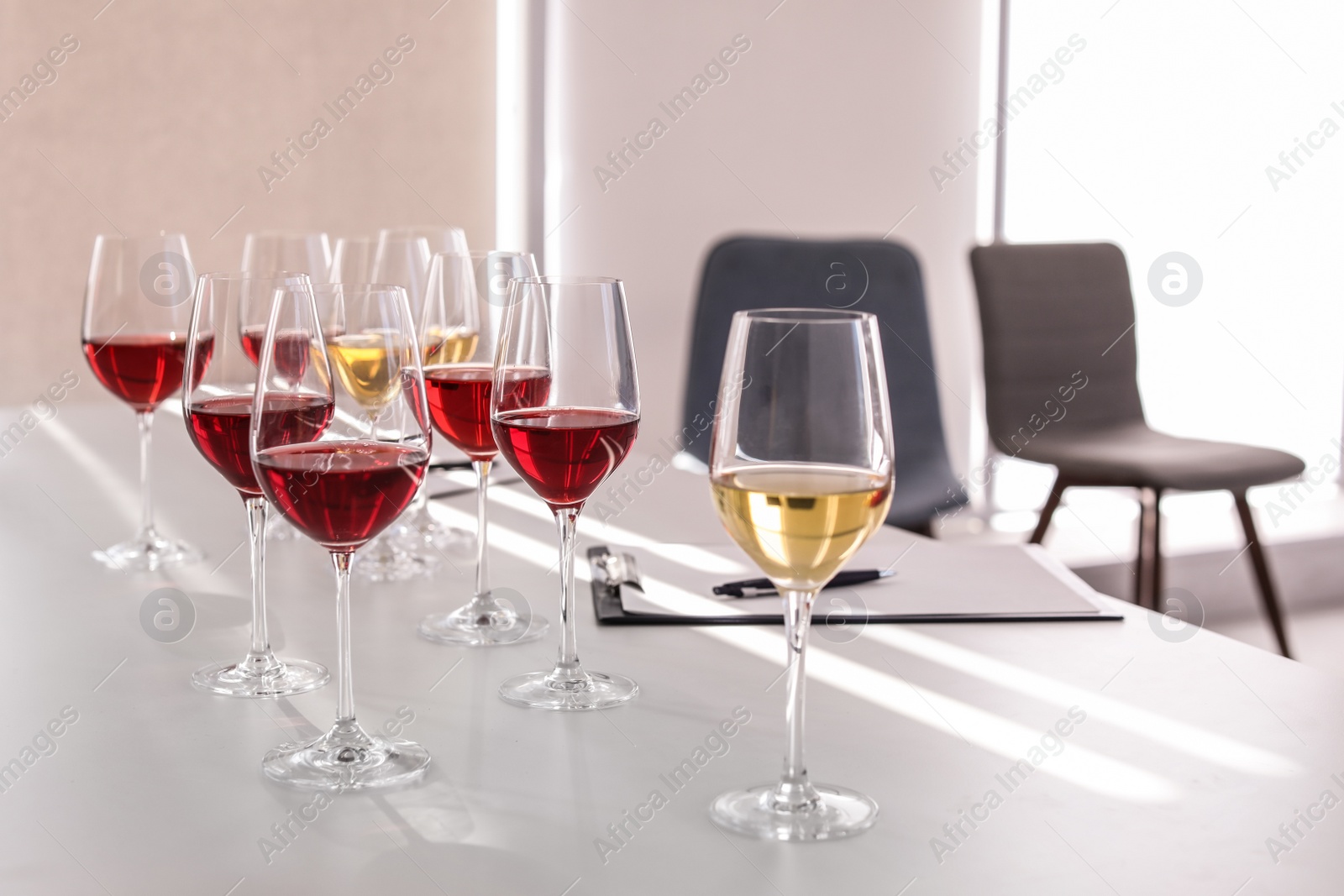 Photo of Glasses with delicious wine on table indoors