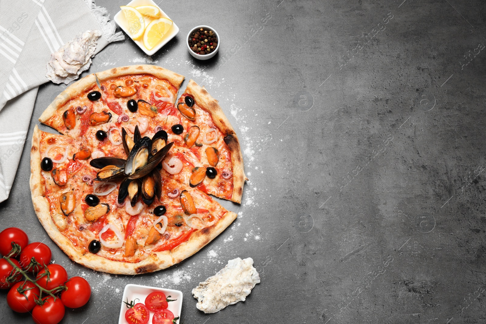 Photo of Tasty pizza with seafood and ingredients on grey table, flat lay. Space for text