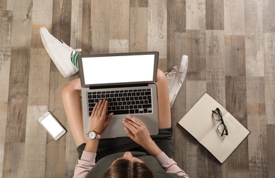 Photo of Top view of woman with laptop sitting on floor, closeup. Mockup for design