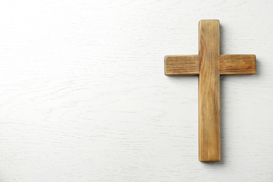 Christian cross on white wooden background, top view with space for text. Religion concept