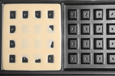 Belgian waffle maker with dough, top view