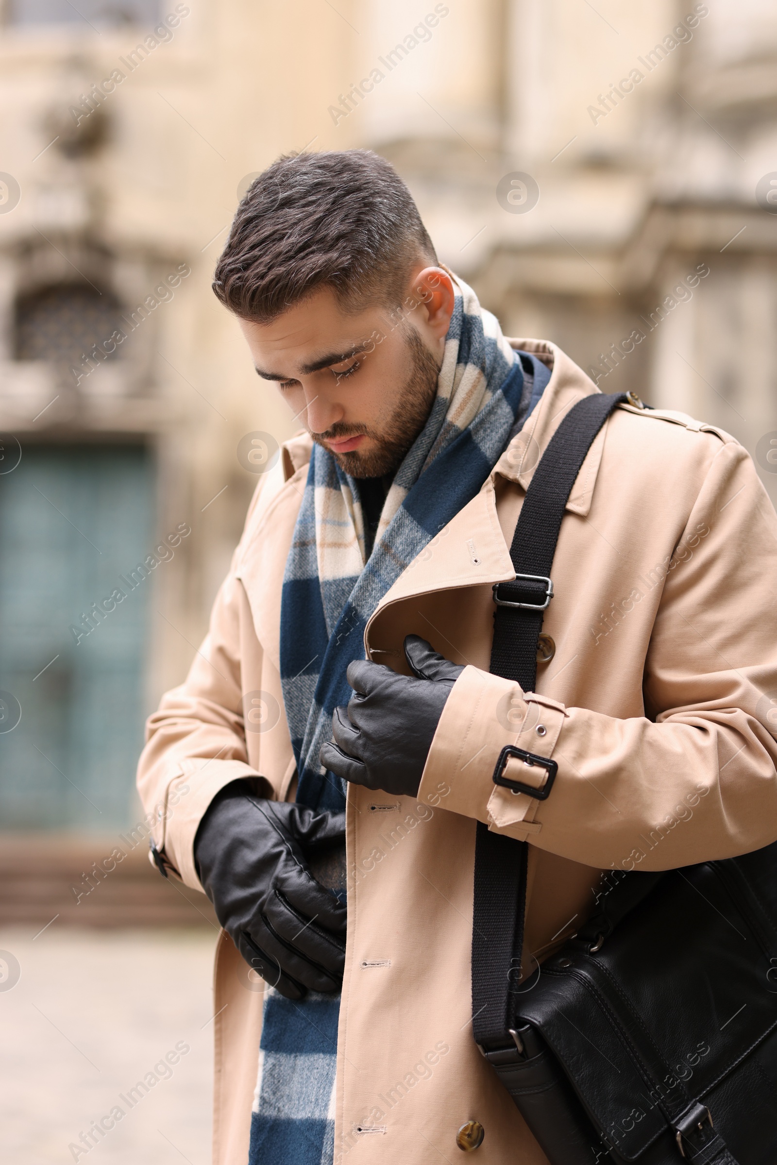 Photo of Handsome man in warm scarf on city street