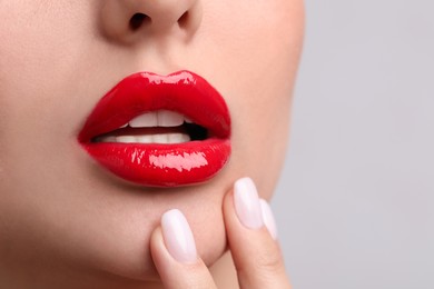 Young woman with perfect lips makeup on light background, closeup