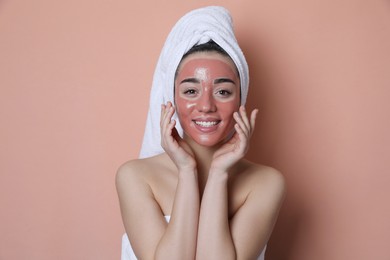 Photo of Woman with pomegranate face mask on pale coral background