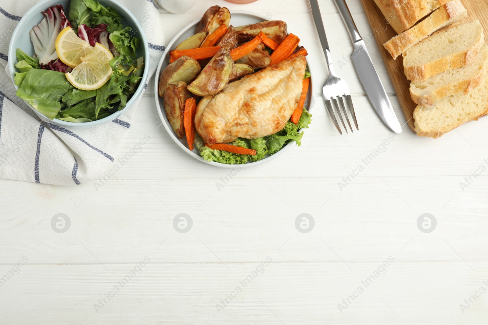 Photo of Delicious cooked chicken and vegetables on white wooden table, flat lay with space for text. Healthy meals from air fryer