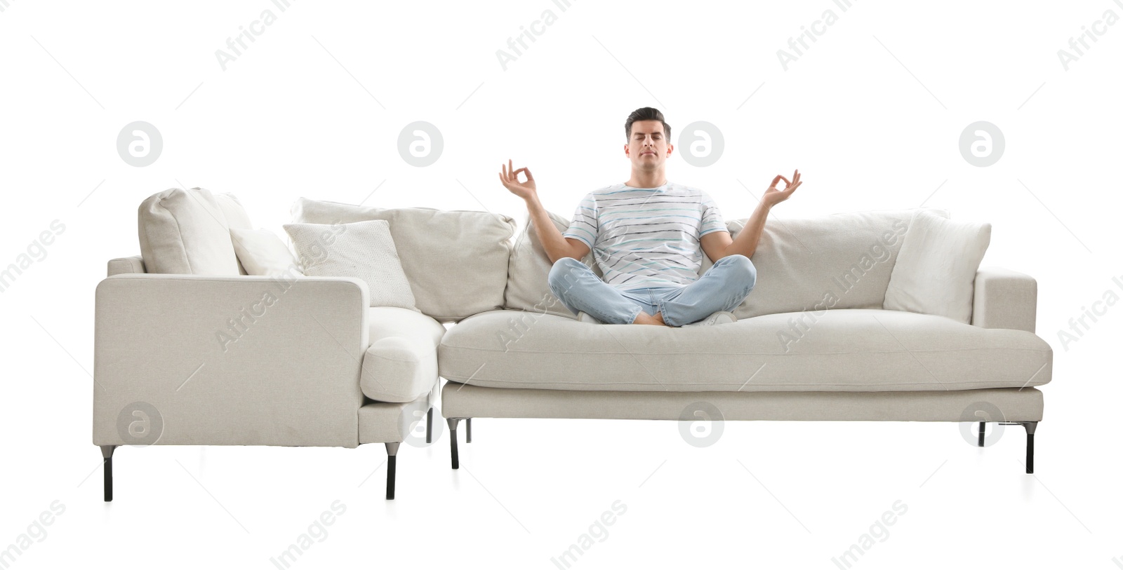 Photo of Man meditating on comfortable sofa against white background