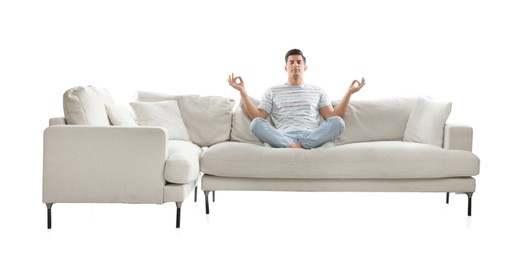 Man meditating on comfortable sofa against white background