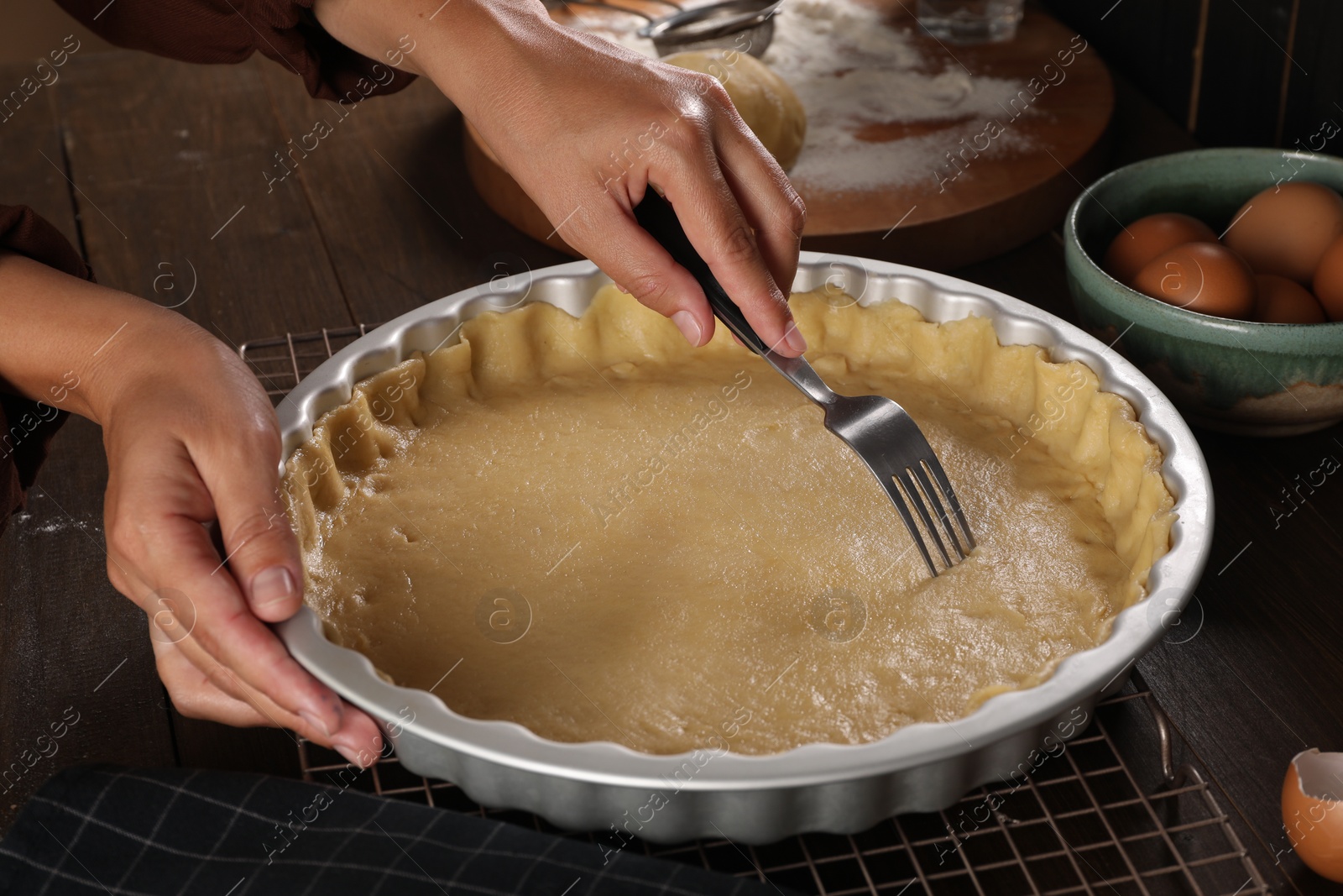 Photo of Woman making quiche at wooden table, closeup
