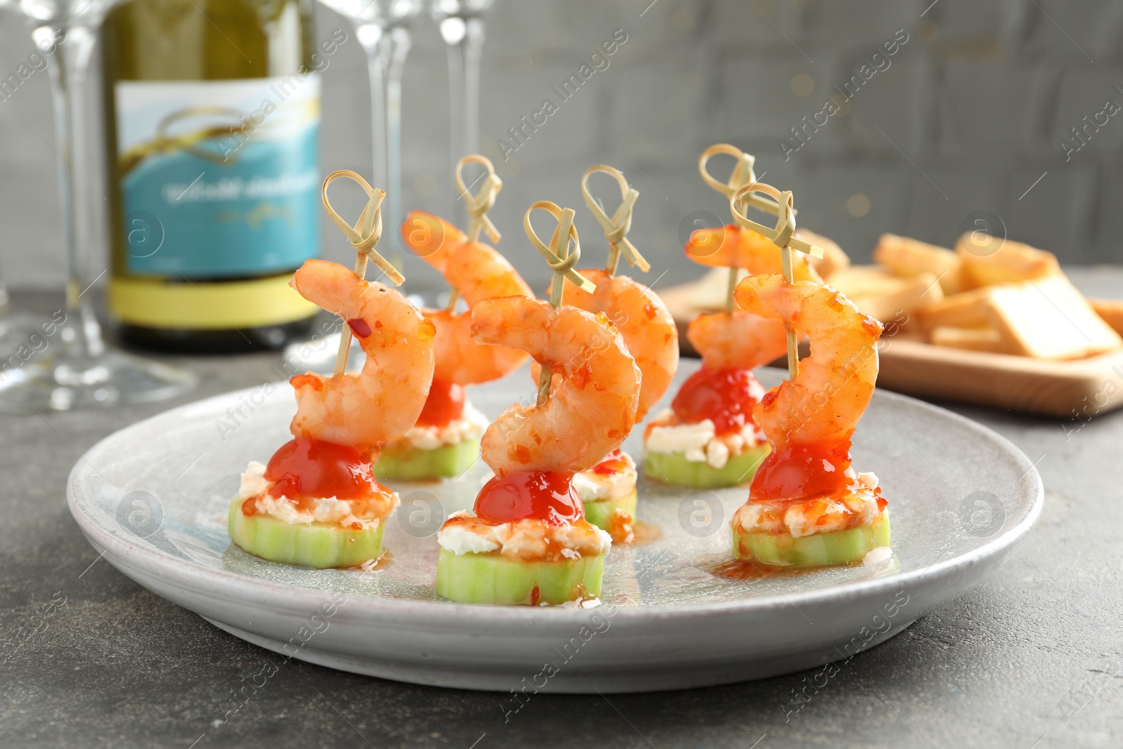 Photo of Tasty canapes with shrimps, vegetables and cream cheese on grey table