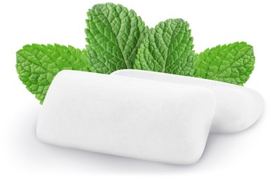 Menthol chewing gum pillows and mint leaves on white background