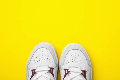 Photo of Pair of stylish shoes on yellow background, top view. Space for text