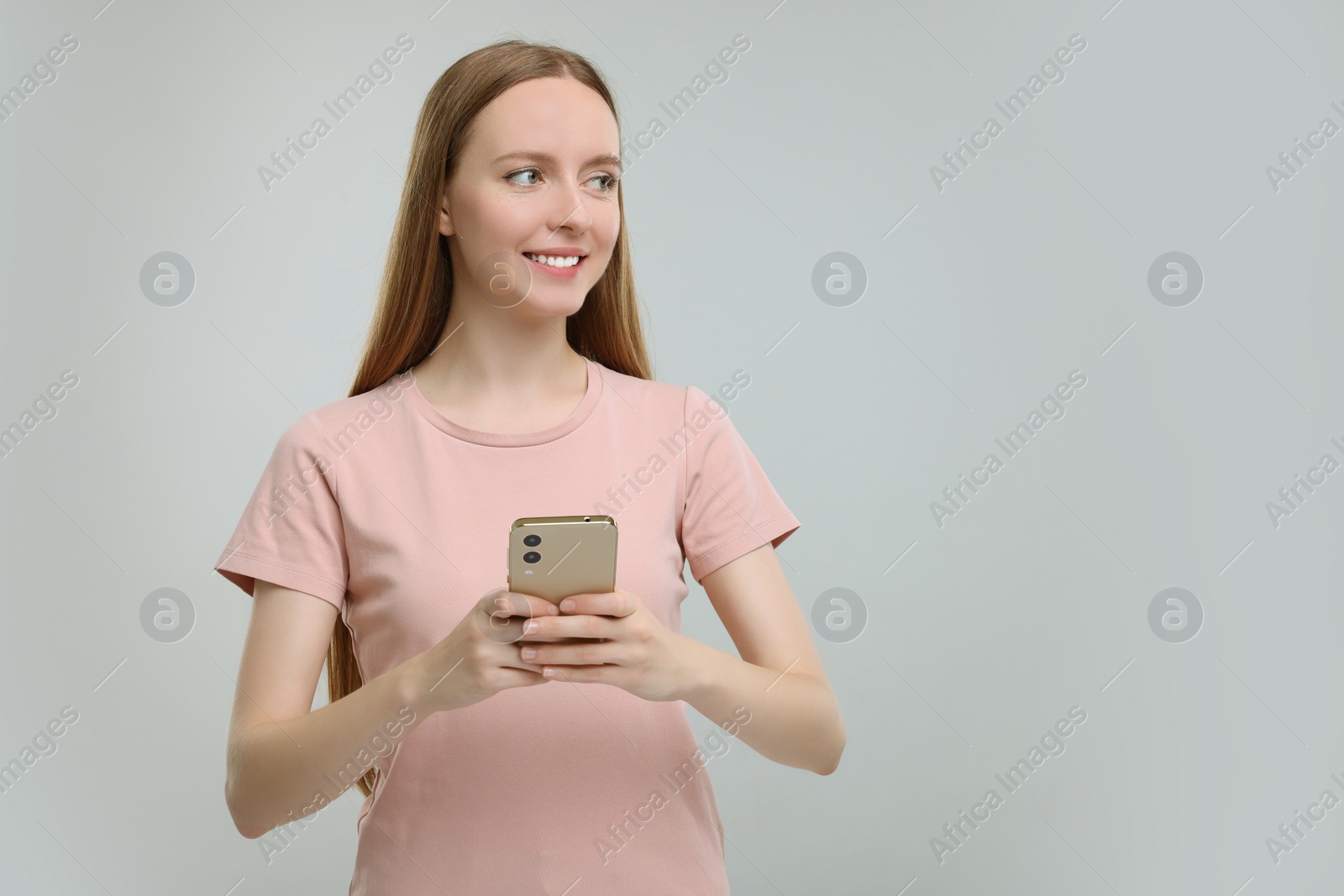 Photo of Woman sending message via smartphone on grey background, space for text