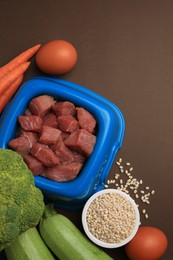 Photo of Raw meat in bowl and healthy products for pet on brown background, flat lay. Space for text