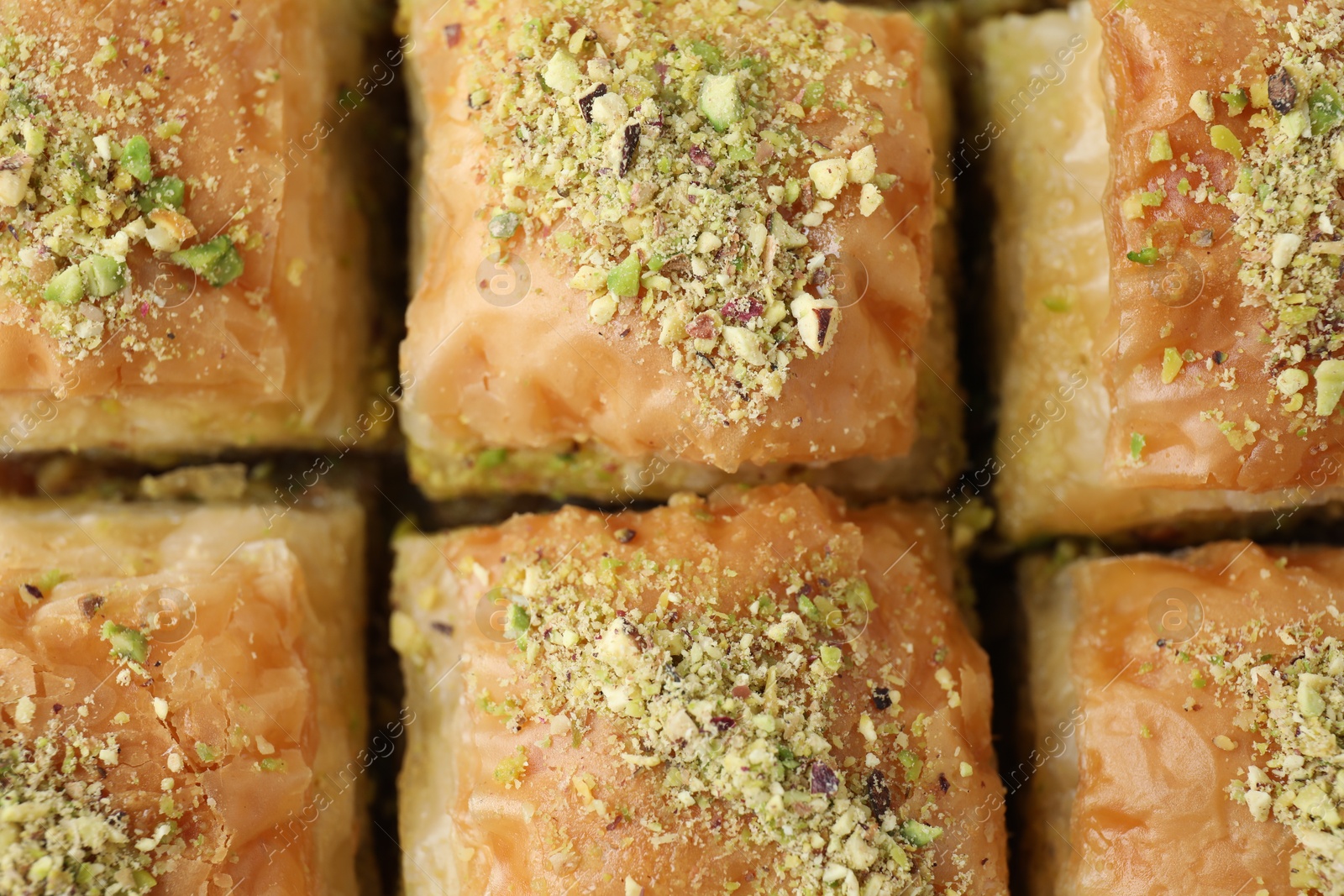 Photo of Delicious fresh baklava with chopped nuts as background, top view. Eastern sweets