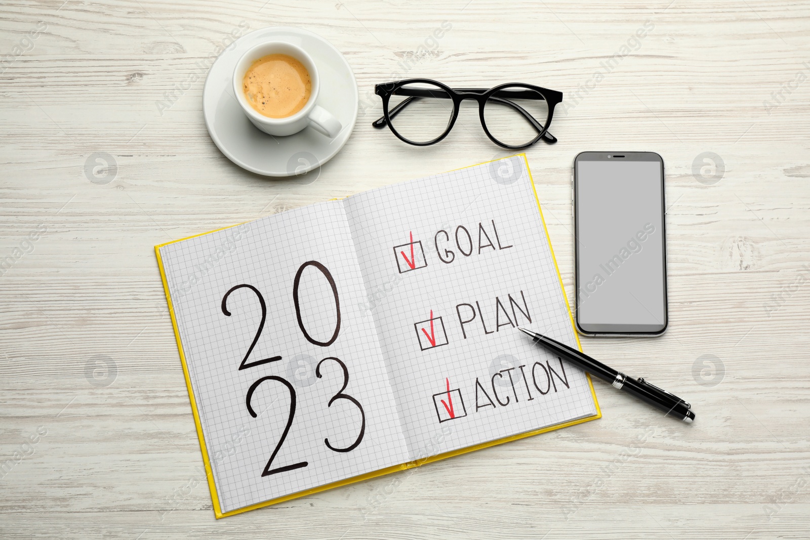 Photo of Flat lay composition of notebook with text 2023 Goal, Plan, Action on white wooden table. New year resolutions