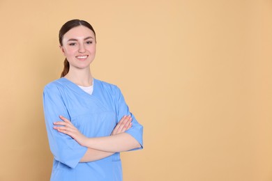 Photo of Portrait of nurse in medical uniform on light brown background, space for text