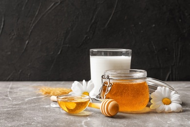 Beautiful composition with milk and honey on table