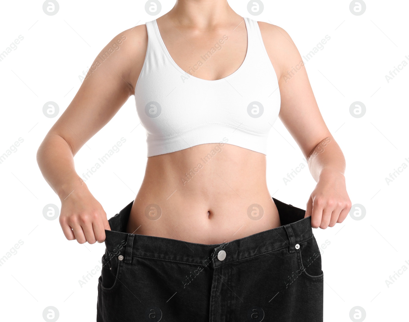 Photo of Young slim woman wearing oversized jeans on white background, closeup