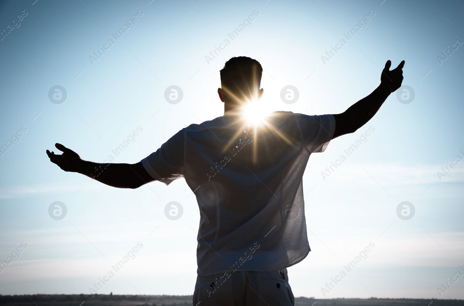 Photo of Man enjoying sunny day, back view. Nature healing power