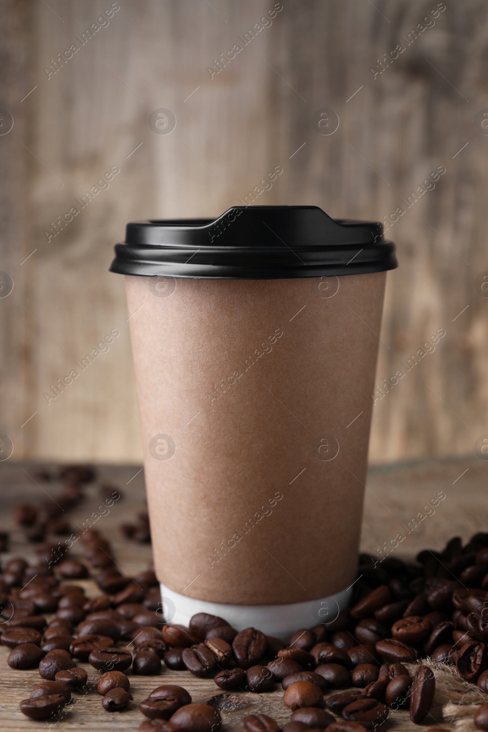 Photo of Coffee to go. Paper cup and roasted beans on table, closeup