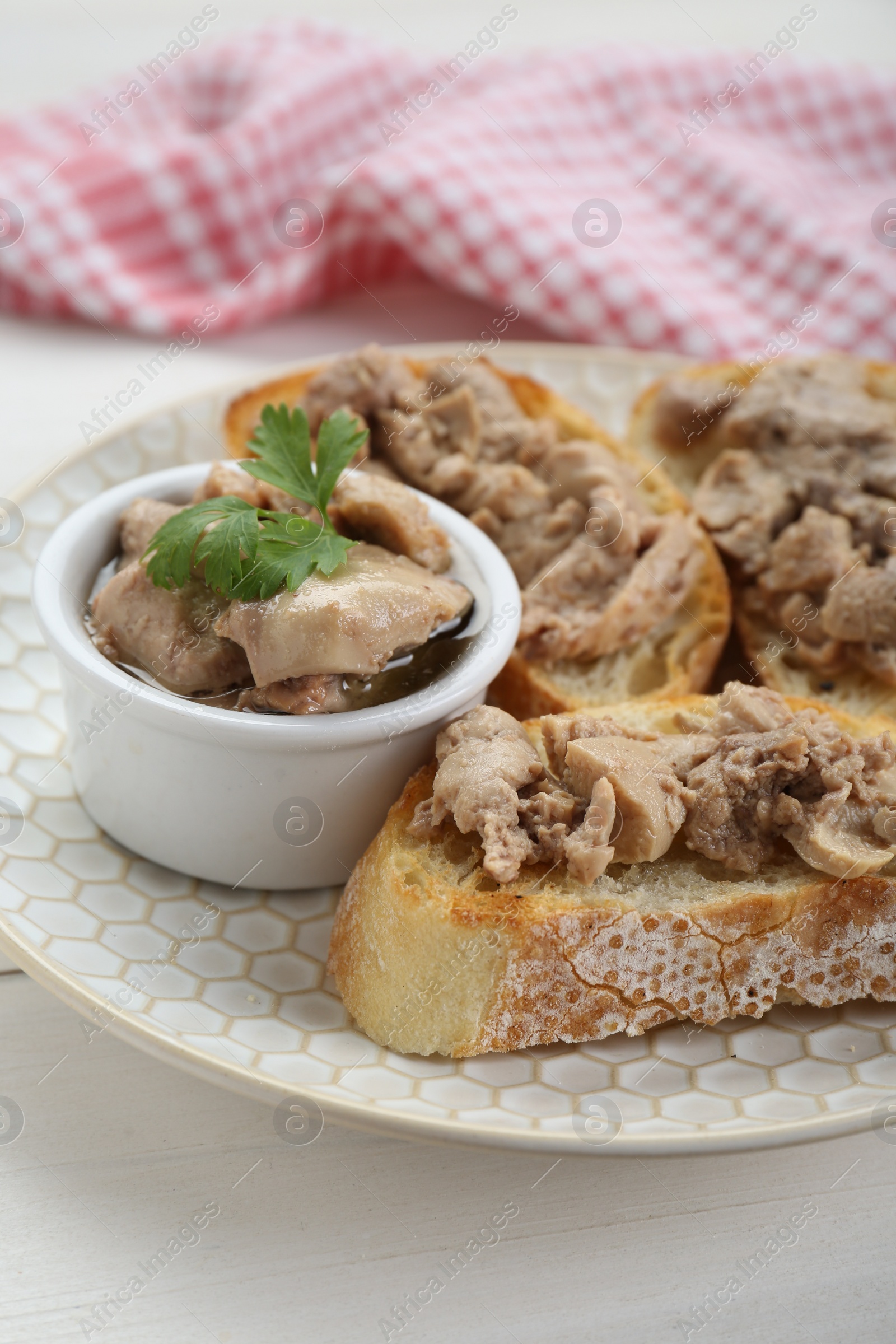 Photo of Tasty sandwiches with cod liver and parsley on white wooden table