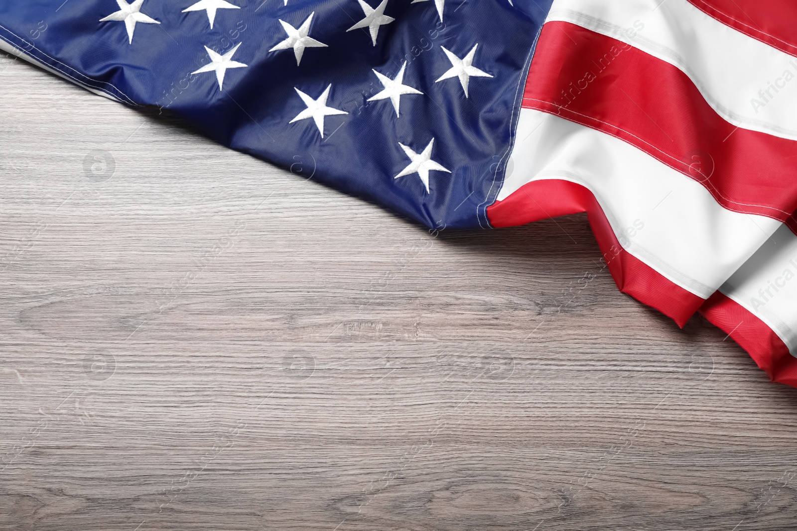 Photo of National flag of America on wooden table, top view. Space for text