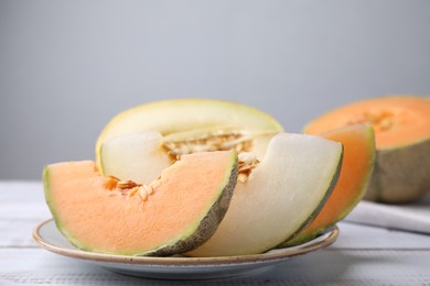 Tasty colorful ripe melons on white wooden table, closeup