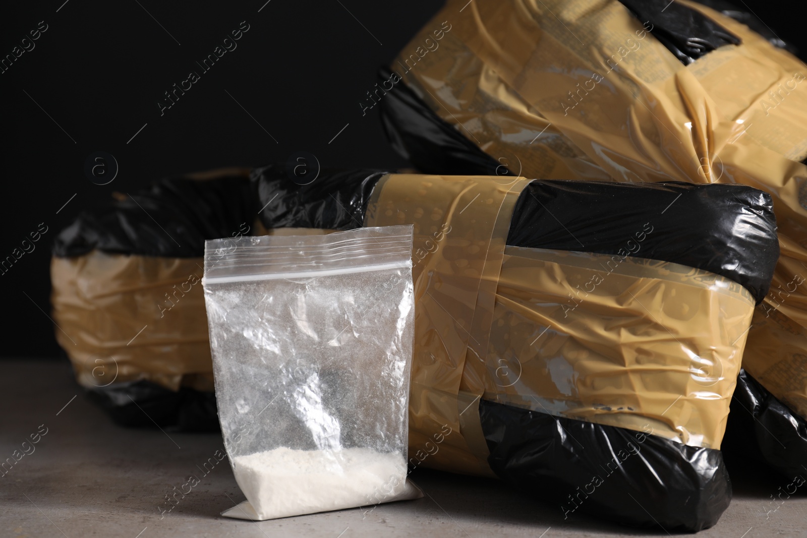 Photo of Smuggling and drug trafficking. Packages with narcotics on grey table, closeup
