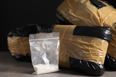 Photo of Smuggling and drug trafficking. Packages with narcotics on grey table, closeup