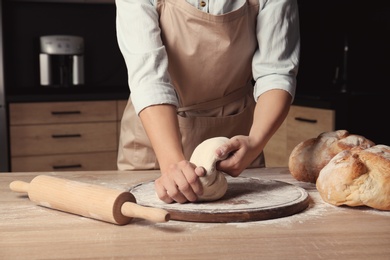 Female baker preparing bread dough at table, closeup