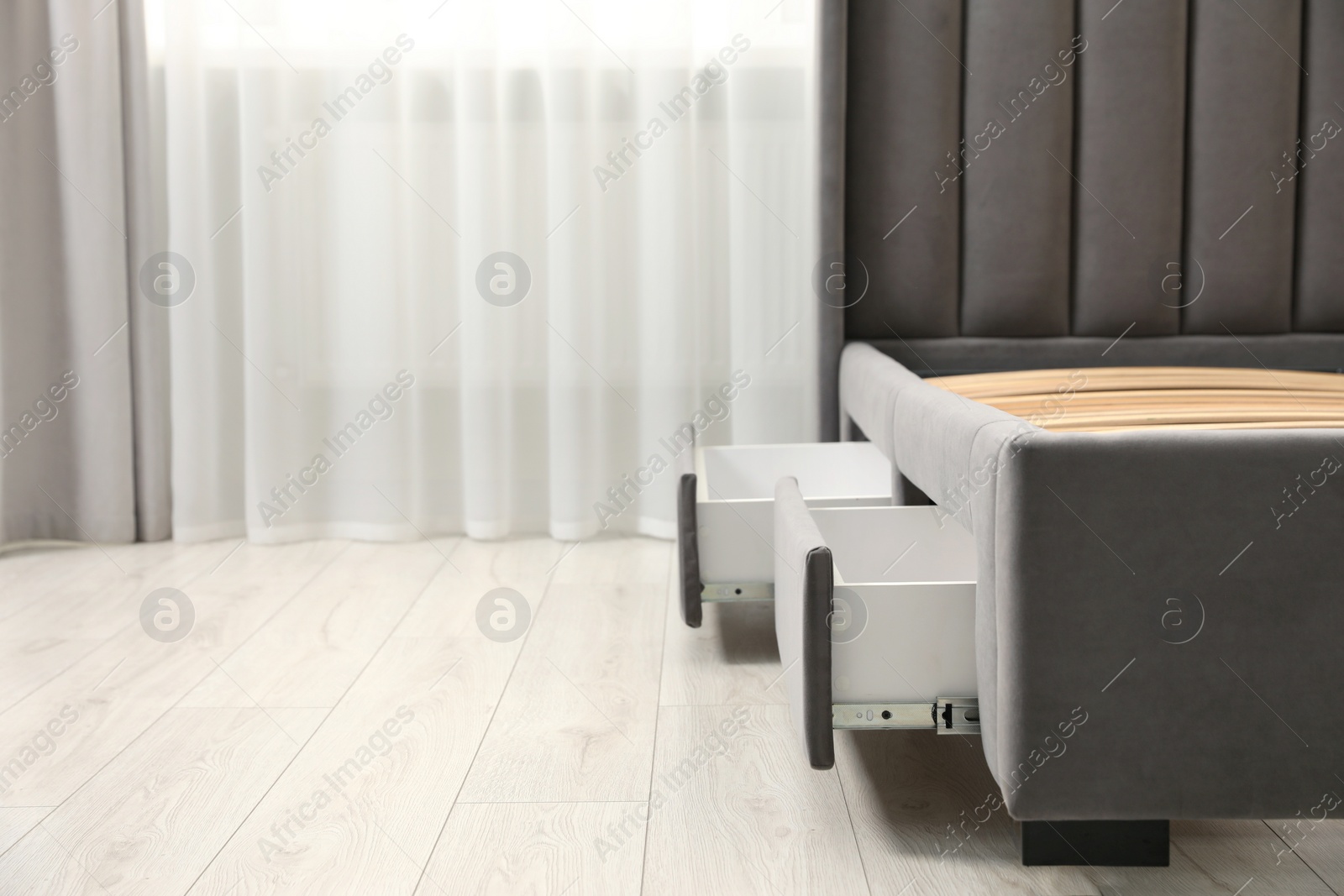 Photo of Storage drawers for bedding under modern bed in room. Space for text