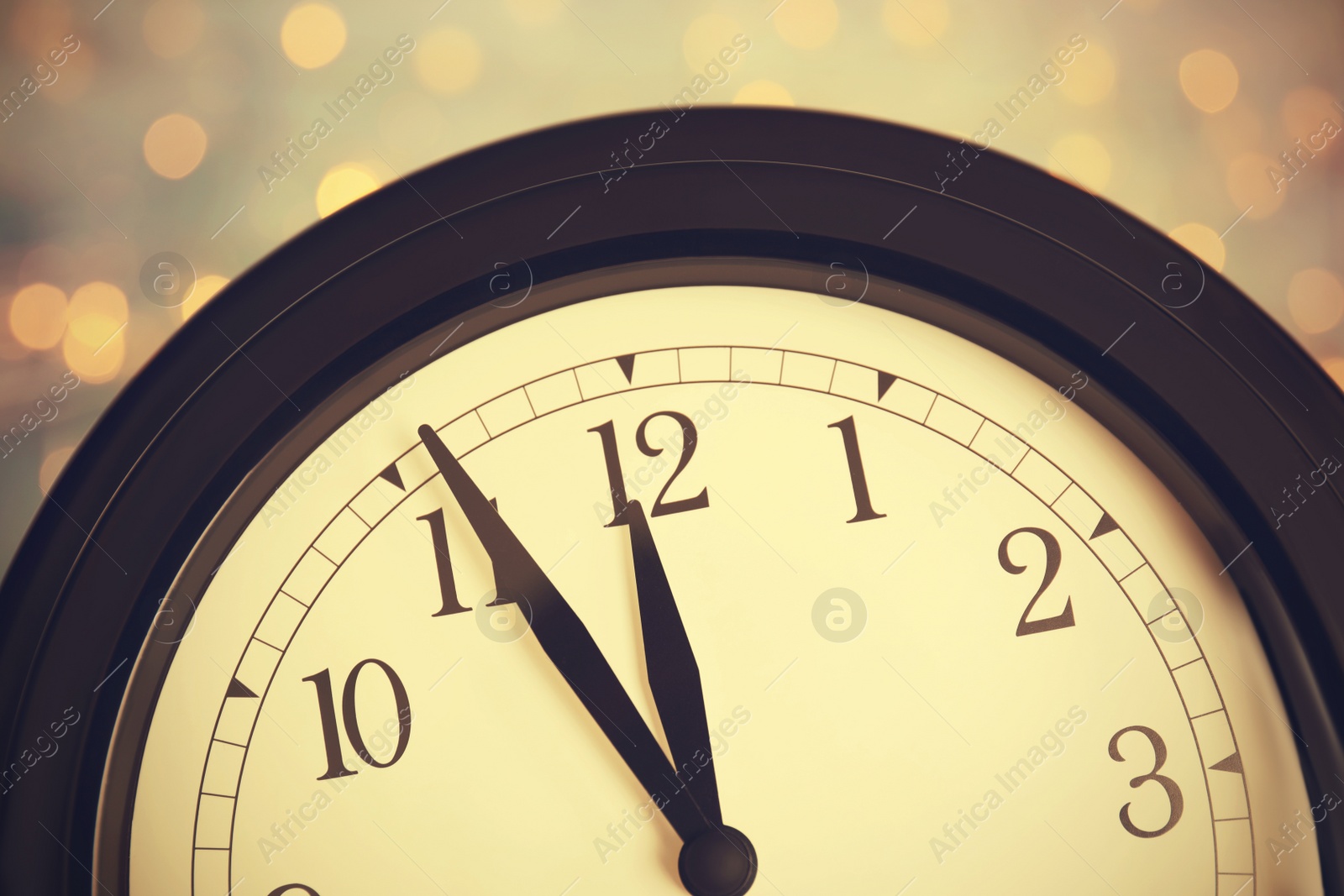 Photo of Clock on color background with blurred lights, closeup. New Year countdown