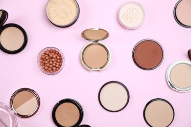 Photo of Different face powders on pink background, flat lay