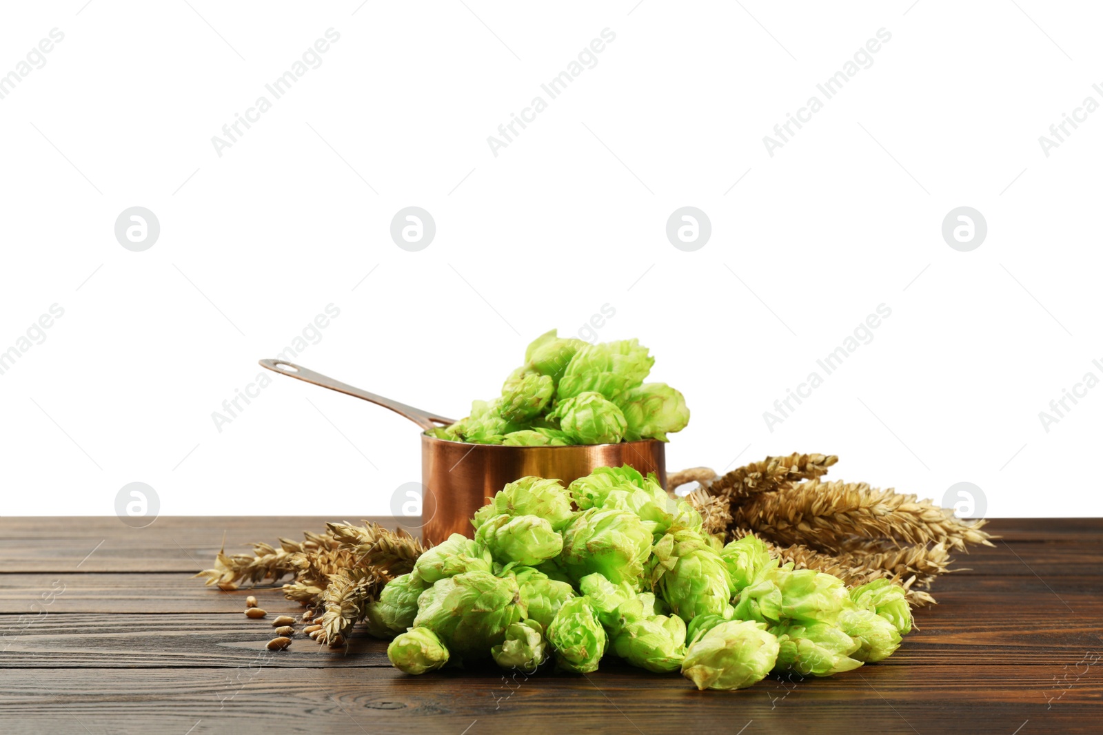 Photo of Fresh hop flowers and wheat ears on wooden table against white background