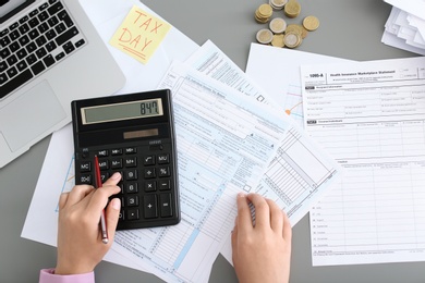 Young female calculating taxes at table, closeup