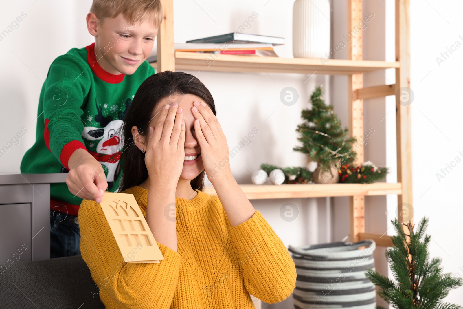 Photo of Happy woman receiving greeting card from her son at home