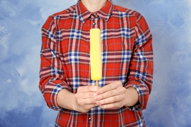 Photo of Woman holding yummy ice cream on color background. Focus on hands