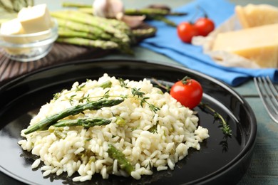 Photo of Delicious risotto with asparagus on table, closeup