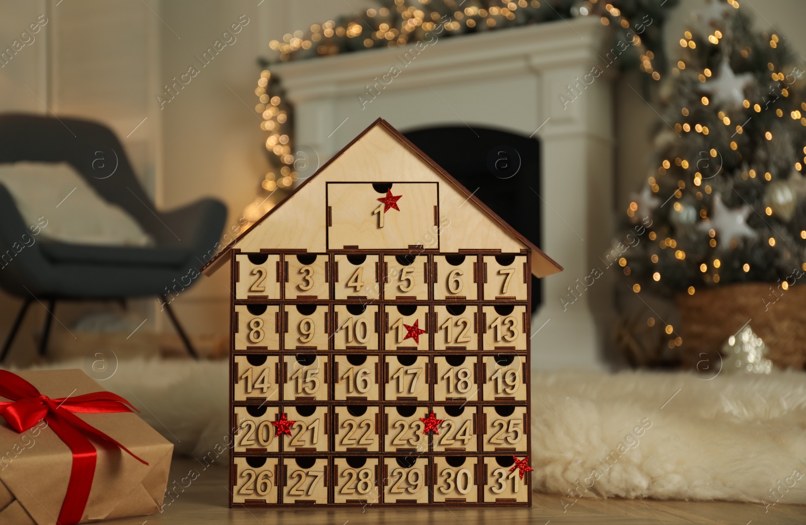 Photo of Wooden house shaped Advent calendar and gift box in room decorated for New Year