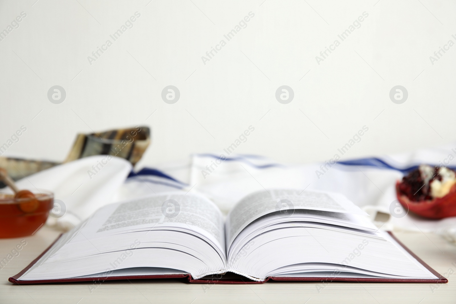 Photo of Open Torah on white wooden table, space for text. Rosh Hashanah celebration