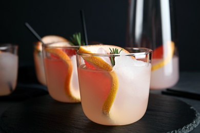 Slate plate with glasses of grapefruit cocktails on table, closeup