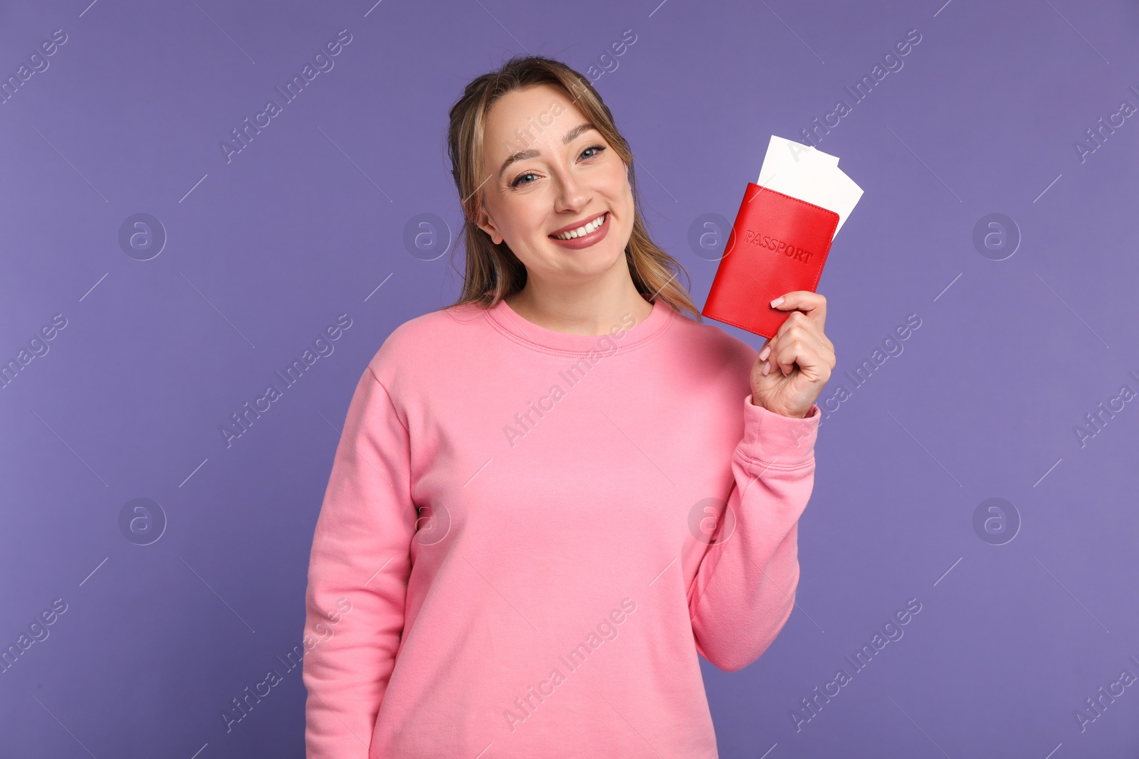 Photo of Happy young woman with passport and ticket on purple background