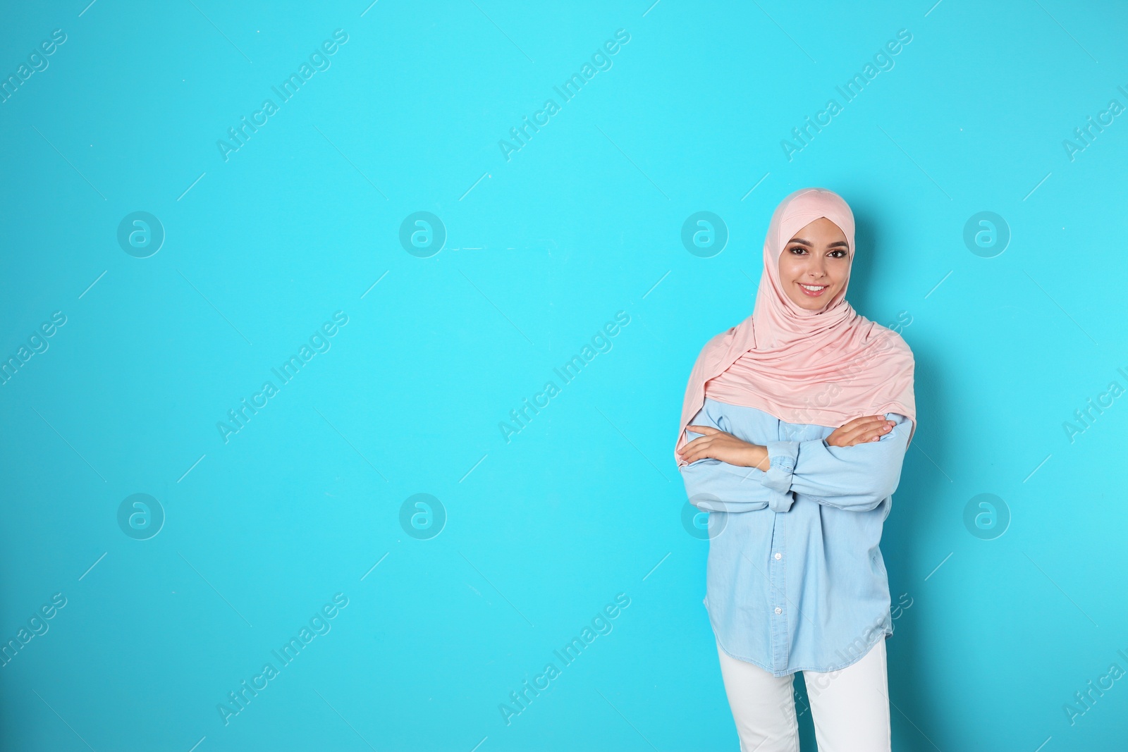 Photo of Portrait of young Muslim woman in hijab against color background. Space for text