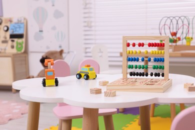 Photo of Different toys on table in playroom. Kindergarten interior