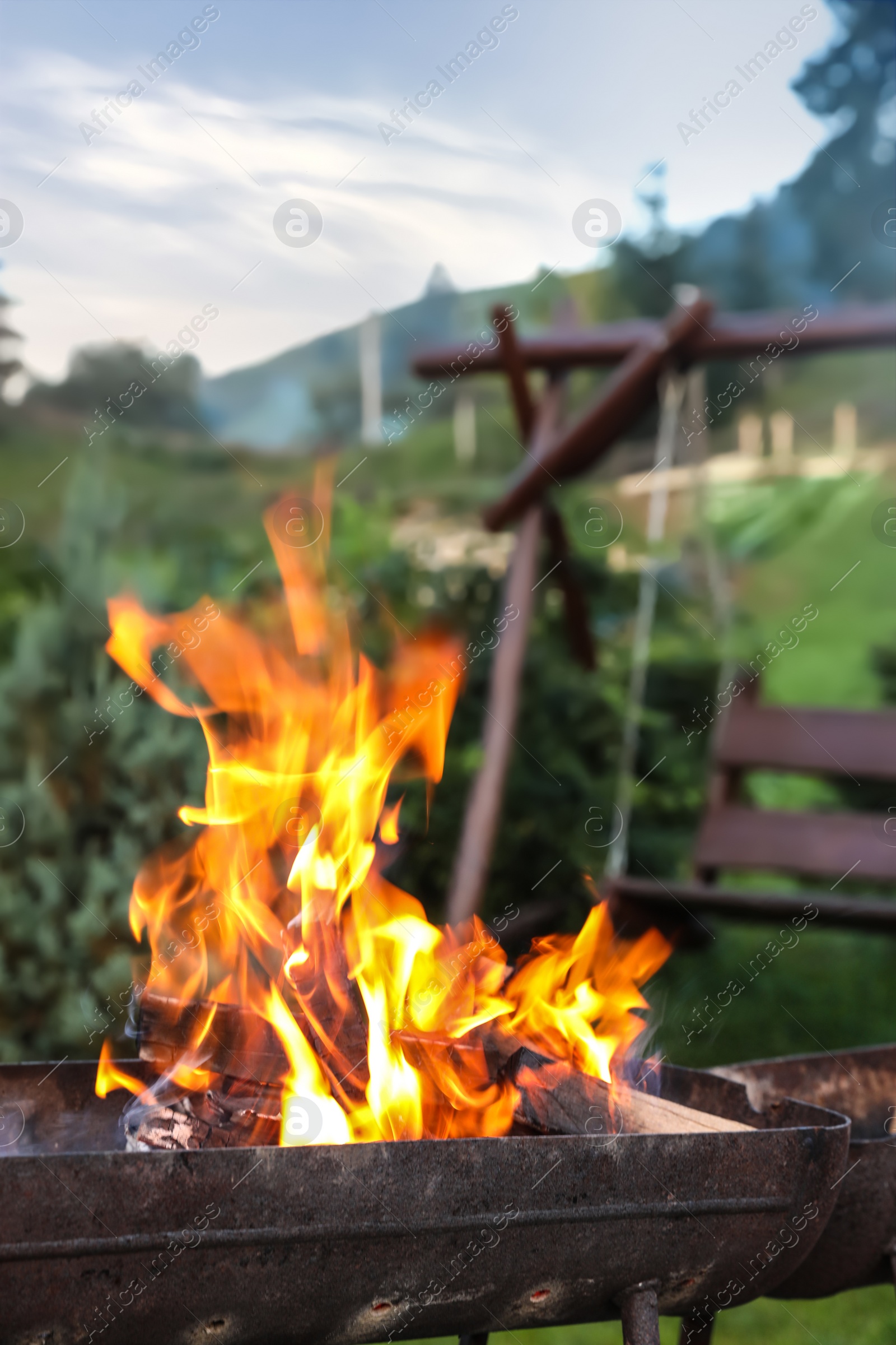 Photo of Close up view of barbecue grill with burning firewood, outdoors