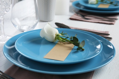 Elegant festive table setting with blank card on white wooden table