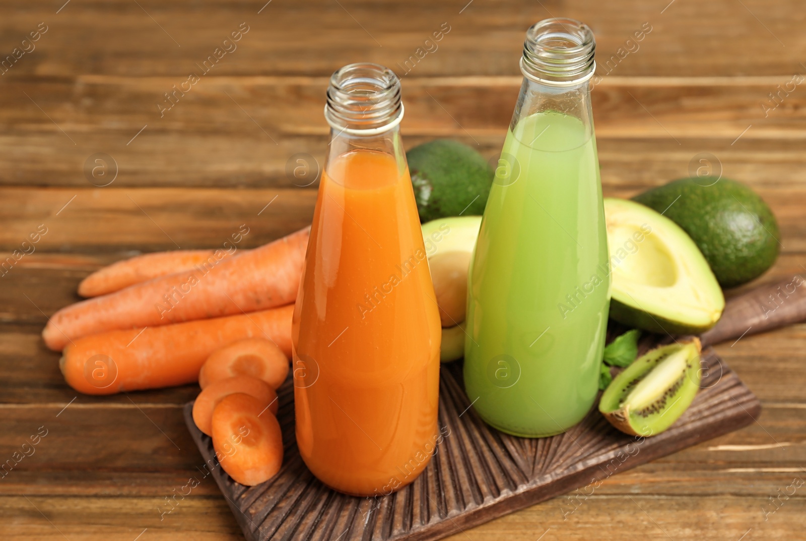 Photo of Bottles with tasty juices and ingredients on table